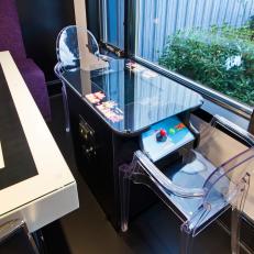Window Side Game Machine With Clear Chairs Next to Black and White Dining Table 