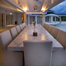 Gorgeously Unique Outdoor Dining Space With Glowing Cracked Stone Table and Uniform Neutral Chairs 