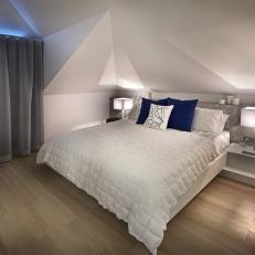 Cozy Modern Bedroom With Low White Ceiling, Built in Bedside Tables and Royal Blue Accent Pillows 