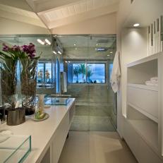 Long Modern Bathroom With Double Vanity Featuring Glass Box Sinks, Glass Shower and Angled Ceiling 