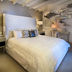 Contemporary Bedroom With White Tufted Headboard, Metallic Fish Wall Decor and Exposed Beam Ceiling 