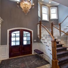 Lovely Traditional Foyer With Arched Wood Doors