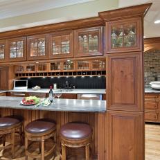 Timeless Basement Bar Features Glass-Front Oak Cabinets, Marble Counters & Handsome Barstools