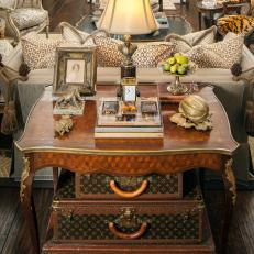 Antique-filled Living Space Featuring a Table Vignette that Includes Antique Louis Vuitton Suitcases