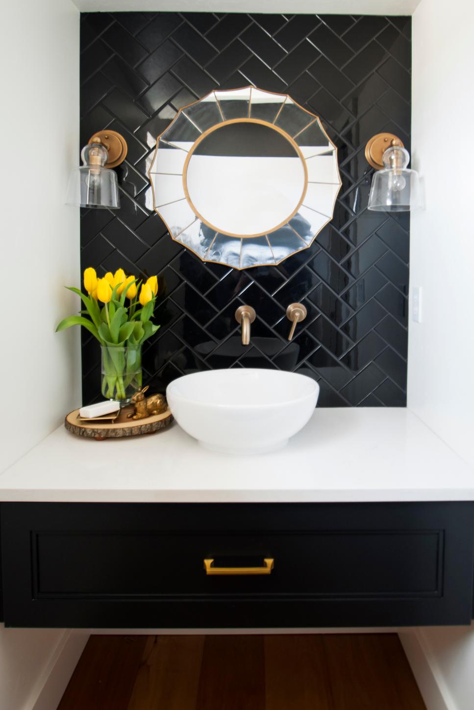 Powder Room Featuring a Black Tile Wall, Art Deco Mirror and White Bowl ...