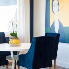 Kitchen Dining Space with White Table, Blue Chairs, Blue-and-Yellow Modern Art and a Neutral, Circular Rug