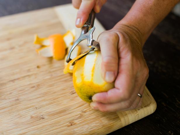 Using a vegetable peeler, peel orange strips, then push whole cloves into the peels.