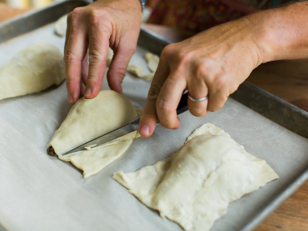 Place pears cut side down on baking sheet with parchment paper. Cut the thawed sheet of puff pastry into 6 rectangles. Place one rectangle on each pear then trim excess dough with a knife.