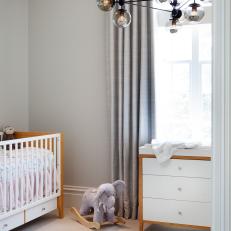 Neutral Nursery with Modern Furniture and Light Fixture