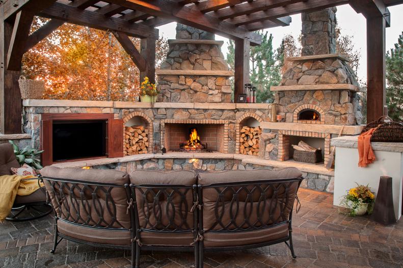 Rustic Patio With Wood Pergola, Stone Fireplace and Curved Sofa