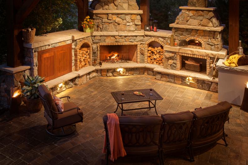 Rustic Patio With Large Stone Fireplace and Cushioned Seating