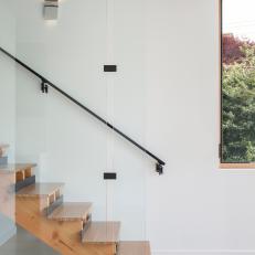 Wall of Glass Panels Encloses Modern Wood Stairs