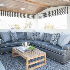 Sunny Rooftop Patio With Cozy Gray Sofa and Graphic Accents