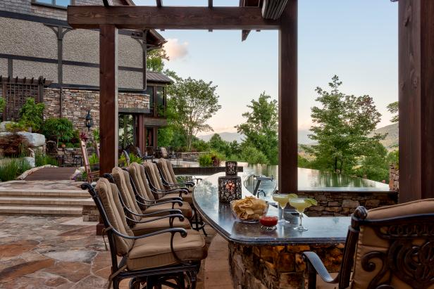 Rustic Outdoor Bar With Neutral Cushioned Barstools & Mountain View