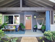 “The front porch is about 8 feet deep by roughly 20 feet wide,” says interior designer Brian Patrick Flynn. “It’s enough to function as an outdoor room.” An all-weather rug, teak sofa and colorful coffee table carve out the conversation area. 