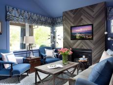 A bold blue color palette, herringbone tiled fireplace and elegant furniture define this eye-catching living room with a balanced sense of masculine and feminine qualities. 