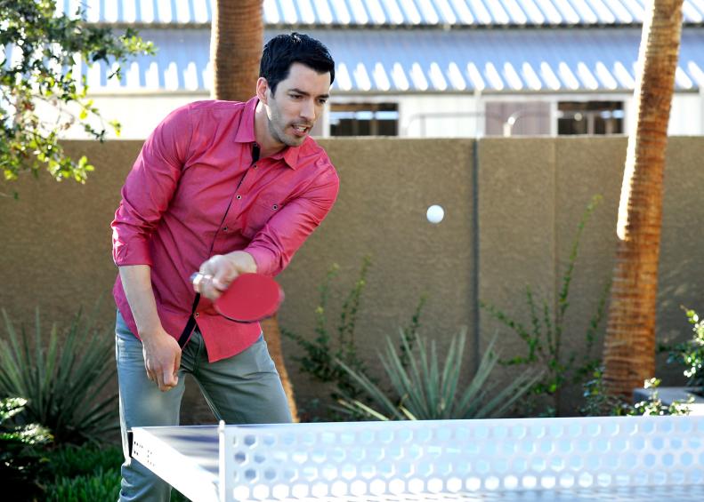 As seen on Brother vs. Brother, Drew Scott plays ping pong with his brother, Jonathan, at their Las Vegas home while waiting the return and the final decision from guest judges realtor David Visentin and designer Hilary Farr on which brother won the bedroom and bathroom challenge.  The winning brother gets to watch the other perform a humiliating dare which included eating 20 hot wings and having a bucket of hot sauce poured over him.