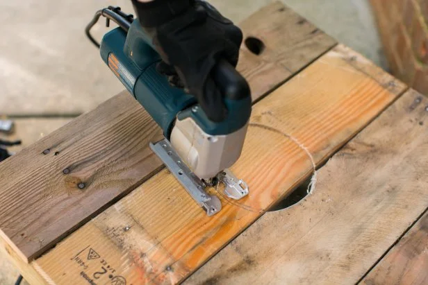 Mark the hole’s location by first centering horizontally, (at the 12 inch mark) then drop down vertically about 6 inches from the top of the board to make another mark (Image 11). This marks where the top of the corn hole will go. Trace around a 6 inch diameter object (Image 12), then using a jigsaw, cut the hole out (Image 13).