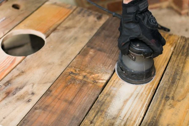 Using a palm sander and a fine grit paper, sand the rough spots down so that the bags will slide a bit when they hit the boards (Image 14). Dust off boards after sanding. To add vintage color, dip the tip of a dry brush into latex paint, barely getting paint on the bristles. Using this dry brush method, lightly sweep color onto the boards (Image 15). To add a white stripe, protect the sides using craft paper secured with painters tape. Lightly sweep white spray paint down the vertical center for an aged look (Image 16). Once dry, remove painters tape and craft paper, then …GAME ON