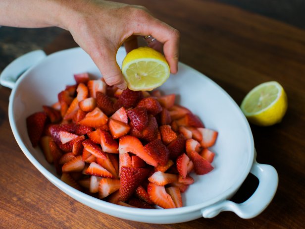 Woman Squirting Lemon Juice on Strawberries 