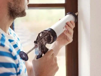 Man Caulking Window