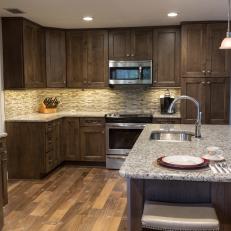 Contemporary Kitchen With Dark Wood Cabinetry And Stainless Steel Appliances