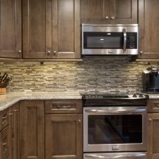 Contemporary Kitchen With Neutral Tile Backsplash And Dark Wood Cabinets