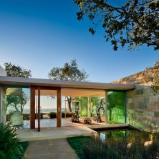 Modern Style Home's Glass Enclosed Hallway And Stone Outdoor Space