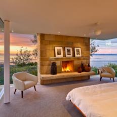 Modern Master Bedroom With Glass Walls And Stone Fireplace