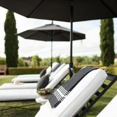 Black and White Poolside Lounge Chairs with Black Umbrellas