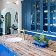 Contemporary White Kitchen Featuring Blue Cabinets and Island with Butcher Block Top