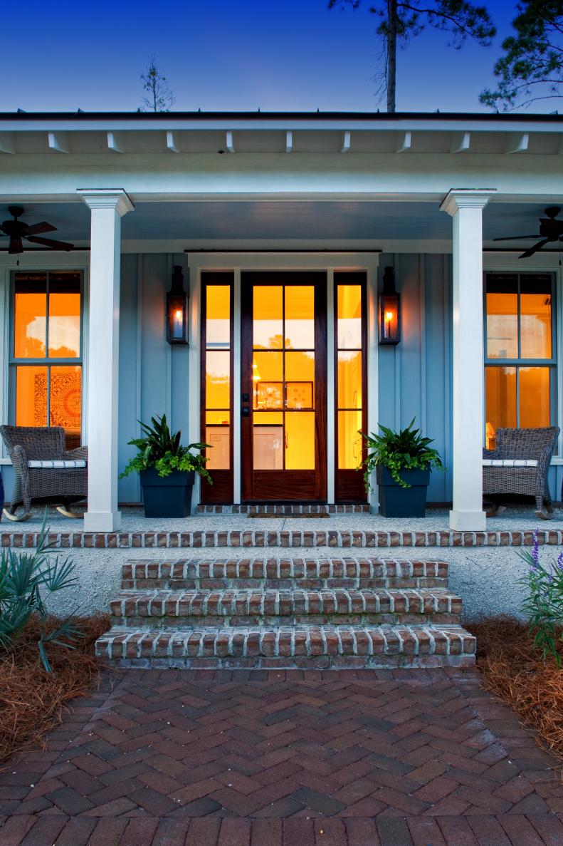 Brick Walkway to Gray Front Porch With White Columns