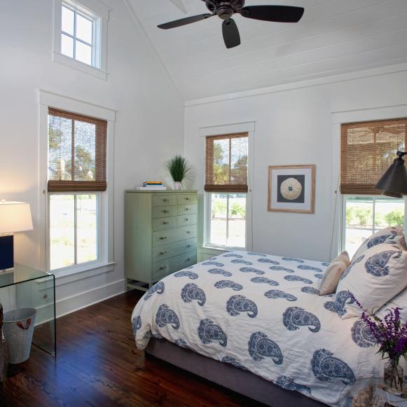 White Country Bedroom With Windows, Green Chest and Wood Floors