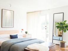 White Bedroom With Orange Rug, Wood Chest and Potted Tree