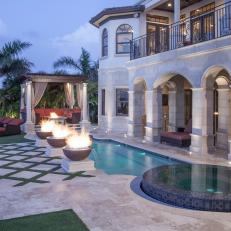 Mediterranean Patio At Dusk Features Infinity Spa, Luxurious Pool, Warming Fire Bowls & Enchanting Lounge