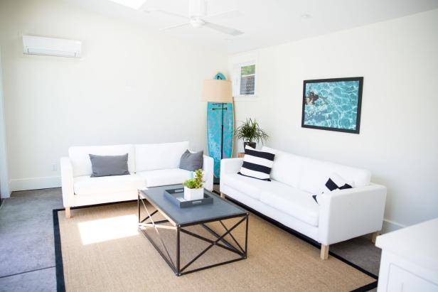 White Living Space With Contemporary White Sofas and Blue Surfboard