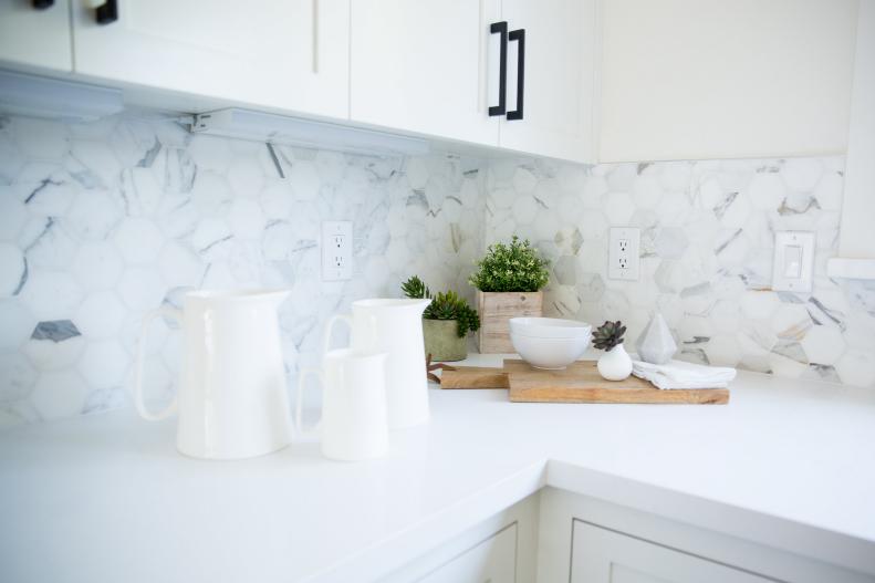 Kitchen With White Cabinets and Marble Backsplash