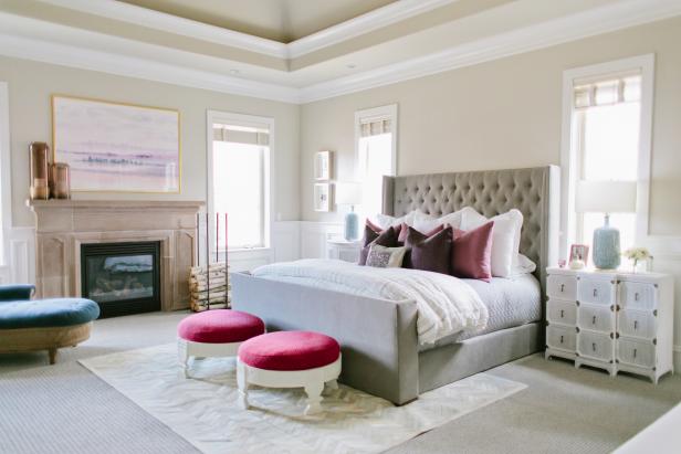 Neutral Transitional Bedroom With Fireplace, Neutral Bed & Pink Stools