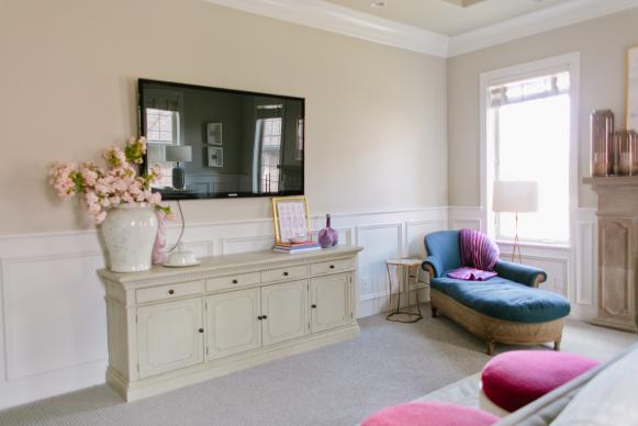 Neutral Transitional Bedroom With TV, White Wainscoting & Blue Chaise