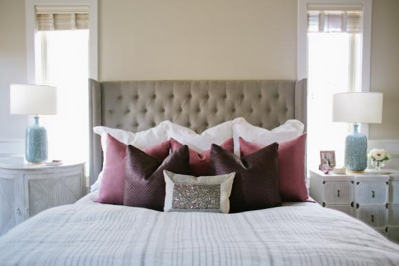 Neutral Transitional Bedroom With Tufted Headboard & Purple Pillows