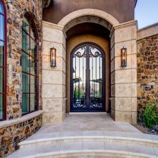 Home Entry with Rustic Rock Walls and Modern Stone Walkway and Arch