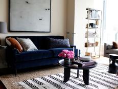 Neutral Living Area With Dark Blue Sofa, Round Table & Stripe Rug