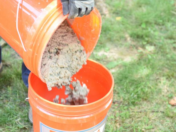 Mix concrete with extra water for a more consistent, pourable mix. Use a mixing tool with a heavy duty drill to make the job a bit easier. Once concrete is ready, pour a 4 inch layer into the bottom of another bucket