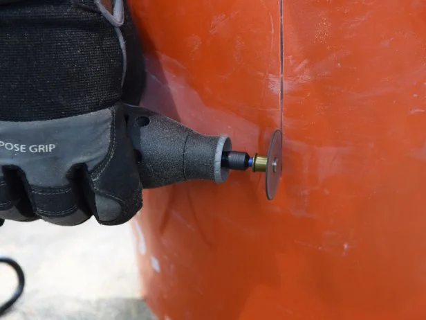 After 24 hours, use a rotary cutting tool to make one vertical cut along the side of the bucket. Then peel the plastic away to reveal the concrete table