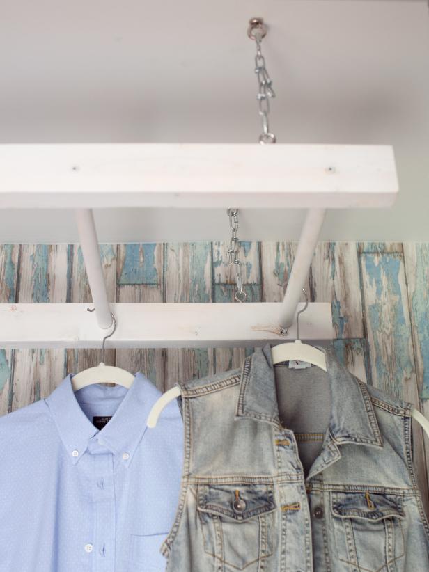 White Clothes Drying Rack Hanging From Ceiling in Laundry Room