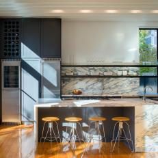 Open Kitchen With Floating Shelves and Marble Island