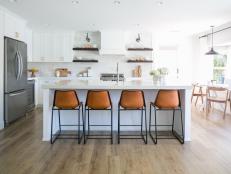 Bright Eat-In Kitchen With Open Shelves and Leather Barstools