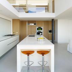 Modern, White Kitchen with Large Island and Orange Stools