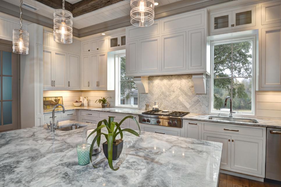 White Kitchen with Large Marble-topped Island and Expansive Cabinets | HGTV