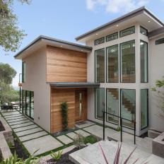 Exterior of Modern Home With Wood Accent Panels, Concrete Walkway & Mulched Landscape 